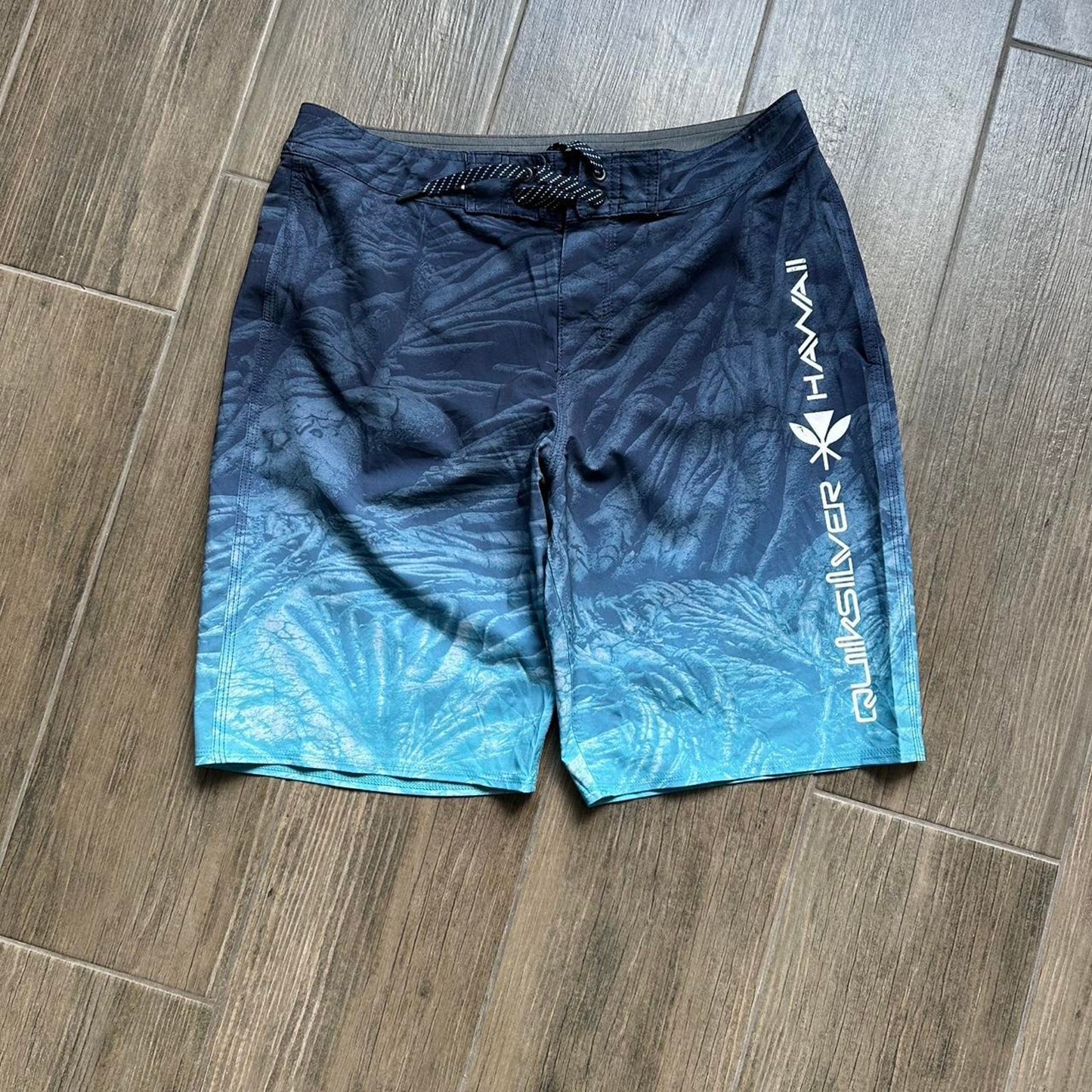 Quiksilver blue board shorts with palm tree design